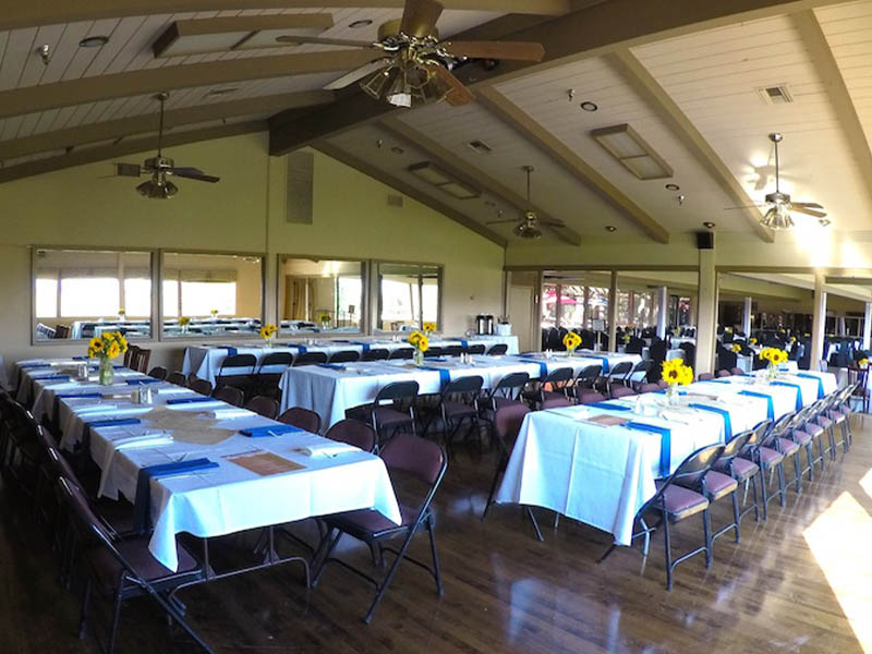 Event room set with banquet tables, white linens, and sunflower centerpieces at Ridgemark Golf Club & Resort.