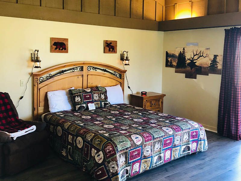 Rustic-themed guest room with patterned bedding and wall art at The Lodge at Ridgemark Golf Club & Resort.
