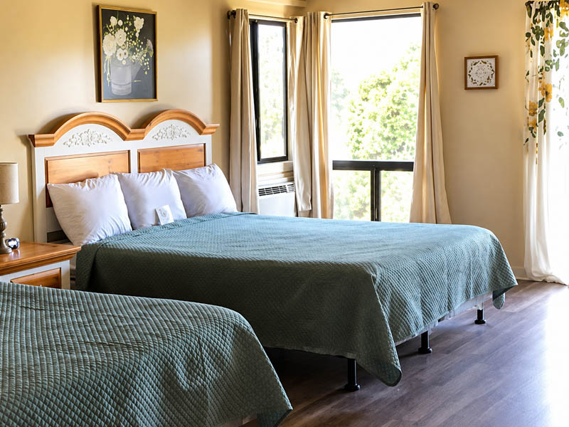 Bright lodge guest room with two beds, large windows, and wood flooring at Ridgemark Golf Club & Resort.