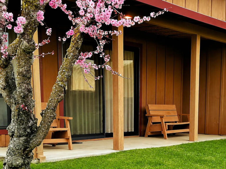 Exterior lodge patio with benches and blooming tree outside guest rooms at Ridgemark Golf Club & Resort.