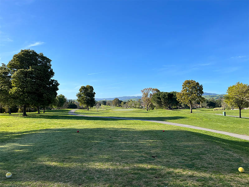 Open fairway at Ridgemark Golf Club & Resort with trees, cart path, and mountain views.