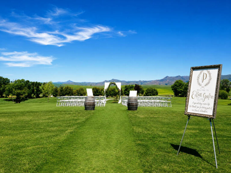 Golf course wedding ceremony site with white chairs, barrels, and mountain views at Ridgemark Golf Club & Resort.